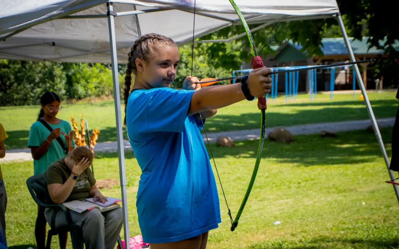 A camper taking aim at the supervised archery range